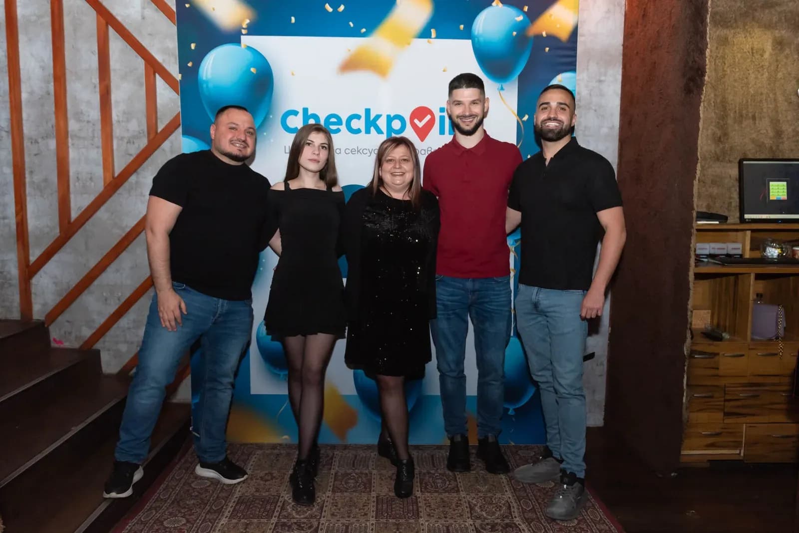 Foto di gruppo davanti allo sfondo della festa di CheckPoint